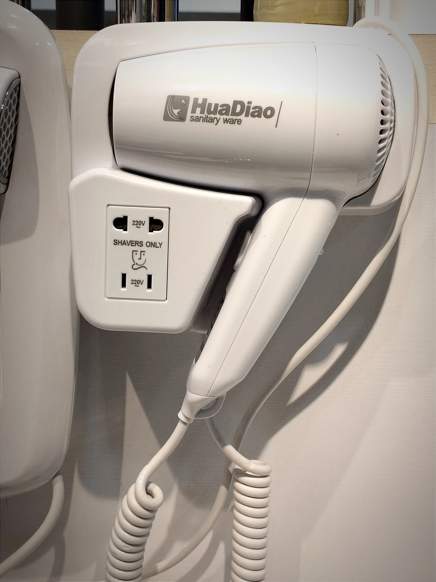 سشوار دیواری با رنگ سفید و مشکی در فضای حمام